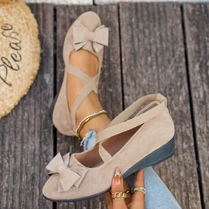 Dettaglio di décolleté con zeppa in camoscio beige con fiocco e cinturini elastici
