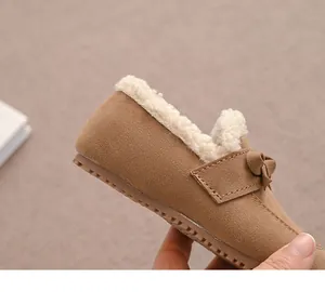 Nahaufnahme von warmen, braunen Mädchen-Loafers mit weichem Plüschfutter und Schleife.