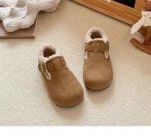 Primer plano de zuecos de invierno para niños en gamuza marrón con forro de pelo