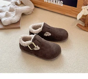 Detalle de zapatos de invierno para niños en ante marrón con forro de lana suave y hebilla.