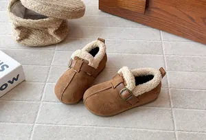 Detail view of brown suede children's warm plush-lined slip-on shoes with a buckle strap