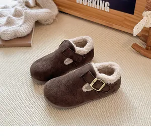 Primer plano detallado de zapatos infantiles de ante marrón forrados de pelo con hebilla metálica