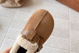 Close-up detail of girls' matte brown slip-on shoes with warm white fleece lining
