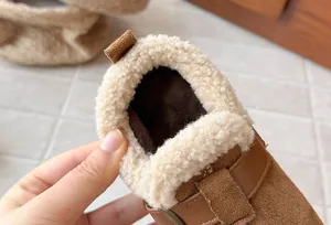 Close-up of cozy cream faux fur lining inside brown suede winter loafers for kids