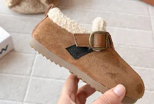 Close-up of warm brown suede girls' shoes with cozy fleece lining and buckle detail
