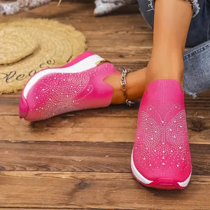 Detailansicht der leuchtend pinken Keilsneaker mit Strass-Schmetterlingsmuster