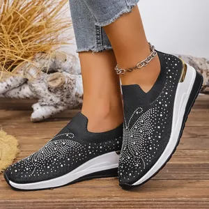 Detailansicht schwarzer Keilsneaker mit funkelnden Schmetterlingsmustern aus Strass
