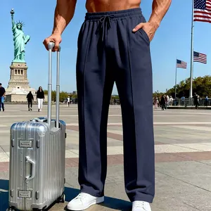 Men's navy blue straight-leg knit joggers shown in a travel setting with a silver suitcase.