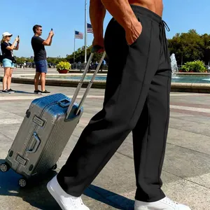 Men's black casual knit straight leg jogging pants shown in a stylish travel setting