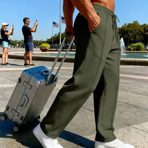 Side view of olive green men's straight-leg casual knit joggers on a model in sunlight