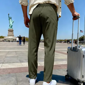 Back view of army green men's joggers worn by a traveler at the Statue of Liberty plaza.