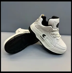 Vista laterale di sneakers in pelle bianca con suola spessa e dettagli testurizzati.