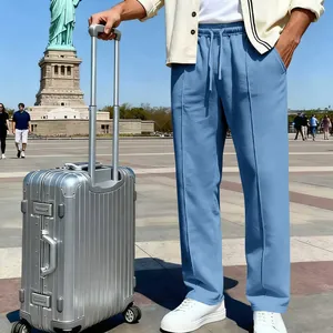 Men's light blue knit joggers with drawstring waist shown in an outdoor travel setting