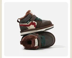 Λεπτομέρεια από καφέ ψηλά sneakers για νήπια με ζεστή επένδυση και πράσινα κορδόνια.
