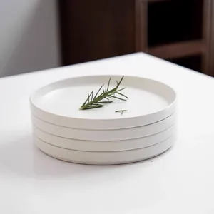 Side view of stacked white ceramic dinner plates featuring a minimalist Nordic design