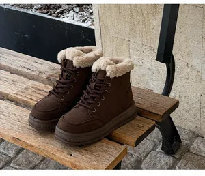 Detail shot of brown winter snow boots with plush faux fur lining on a rustic bench.