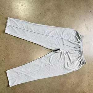 High-angle detailed view of grey knitted mens casual straight-leg pants laid flat on a floor