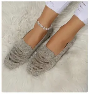Detail of breathable knitted flat loafers with round toe in a casual summer style.