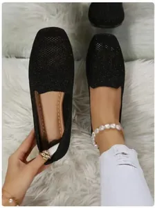 Detailed view of women's black sparkly knitted flat shoes featuring a breathable mesh texture