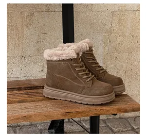 Detail shot of brown suede snow boots with cozy beige faux fur lining on bench.