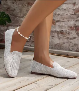 Close-up view of white knit round toe flat loafers featuring a breathable mesh texture