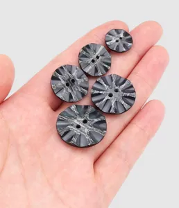 Macrodetail van vijf zwart gemarmerde harsknopen voor hoogwaardige kledingaccessoires.
