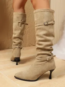 Vista detallada de botas de ante beige con diseño fruncido, punta fina y tacones de aguja
