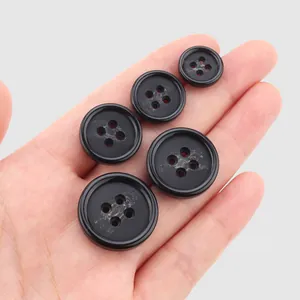 High-end black resin buttons in various sizes for suits and coats, shown on hand