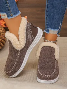 Gros plan de bottes de neige marron avec doublure en fausse fourrure crème et coutures