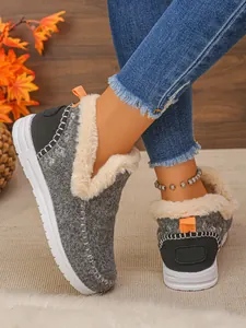 Détail de bottes de neige grises avec doublure en fausse fourrure blanche et languette