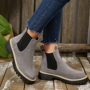 Close-up detail of stylish grey suede Chelsea boots with thick black lug sole