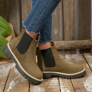 Close-up showing the side profile and thick lug sole of olive green suede boots.