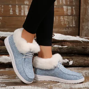 Detailansicht blauer Slipper mit dickem weißem Kunstfellfutter und Schnürsenkeln.