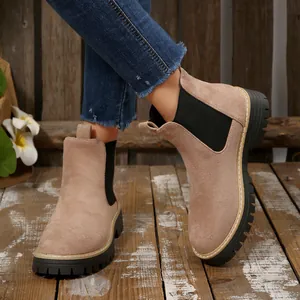 Detail of women's tan suede platform Chelsea boots with thick black soles and contrast stitching