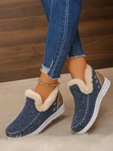 Gros plan des bottines d'hiver en jean bleu pour femmes avec doublure en polaire blanche