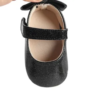 Detailed top view of black glitter baby girl Mary Jane shoes with elegant bow accent