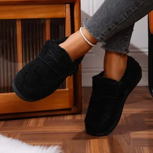 Detail view of women's black fuzzy fleece loafers featuring warm lining and cross straps.