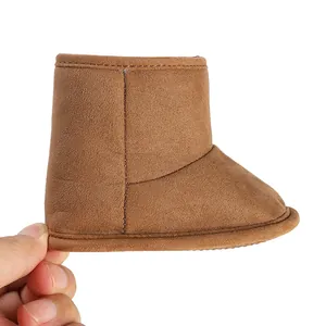 Close-up of a brown infant winter boot showing the soft suede texture and stitching details.