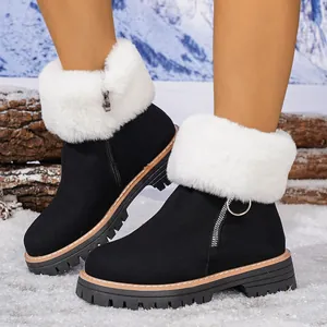 Detail view of black snow boots featuring thick soles and white faux fur trim.