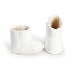 Close-up of white infant winter booties showing soft fleece lining and cozy texture