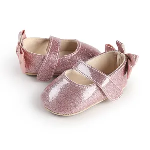 Close-up of pink glitter baby Mary Jane shoes with cute bow detail and soft soles