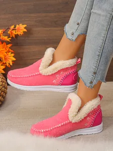 Gros plan sur des bottes d'hiver roses avec doublure en fausse fourrure blanche