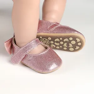 Macro detail showing pink glitter texture and non-slip rubber sole on baby girl walking shoes