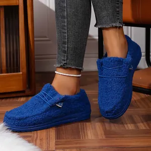 Detailed macro view of blue fuzzy winter slippers featuring plush lining and a rubber sole
