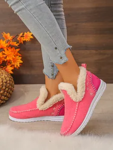 Détail latéral de bottes de neige roses d'hiver avec doublure en fourrure et broderie flocon