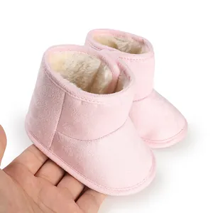 Close-up detail of warm pink baby boots featuring soft plush lining and suede texture