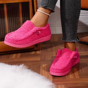 Close-up view of bright pink furry fleece loafers worn by a model for warm winter style