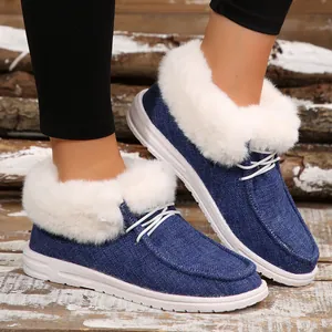Nahaufnahme von blauen Denim-Loafers mit dickem weißem Kunstfellfutter an den Füßen