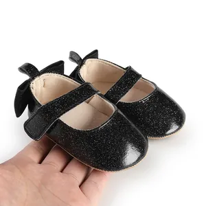 Detailed view of black glitter baby girl Mary Jane shoes with a bow detail on the heel.