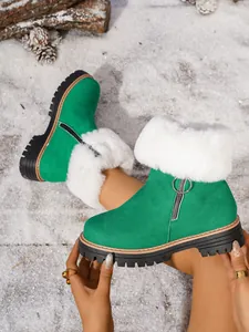 Detailed view of green suede snow boot with white faux fur trim and side ring zipper.